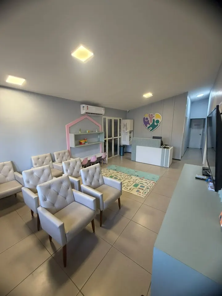 Recepção da Clínica Similar, com poltronas, espaço kids e o logo na parede