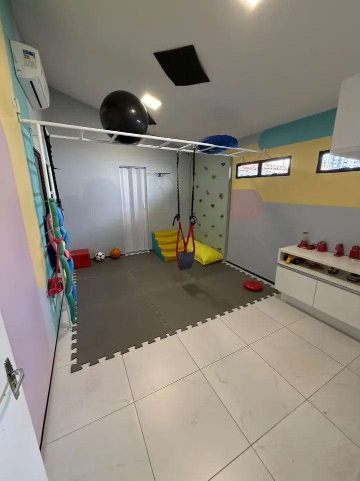 Sala de integração sensorial da Clínica Similar, com balanço, parede de escalada e tatames
